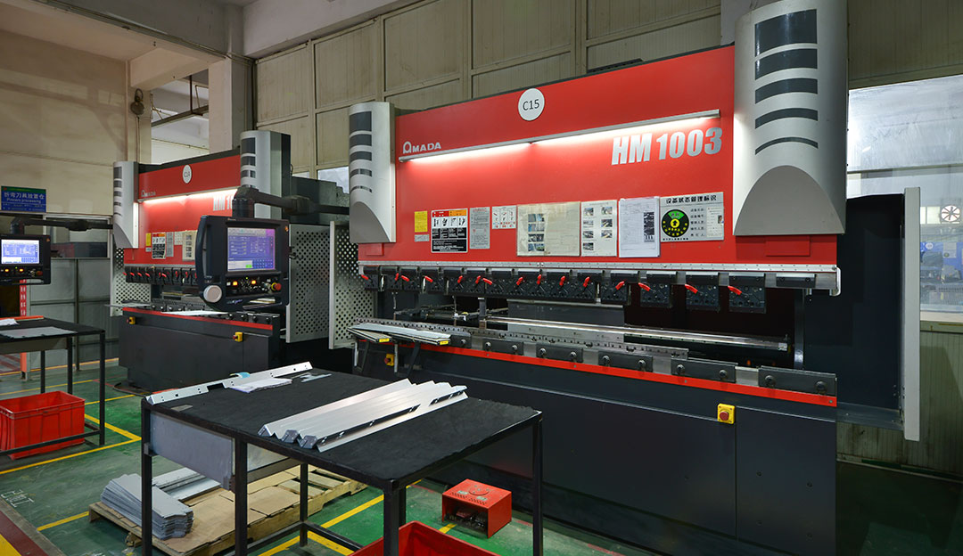 Red sheet-metal processing equipment in a clean production aisle.