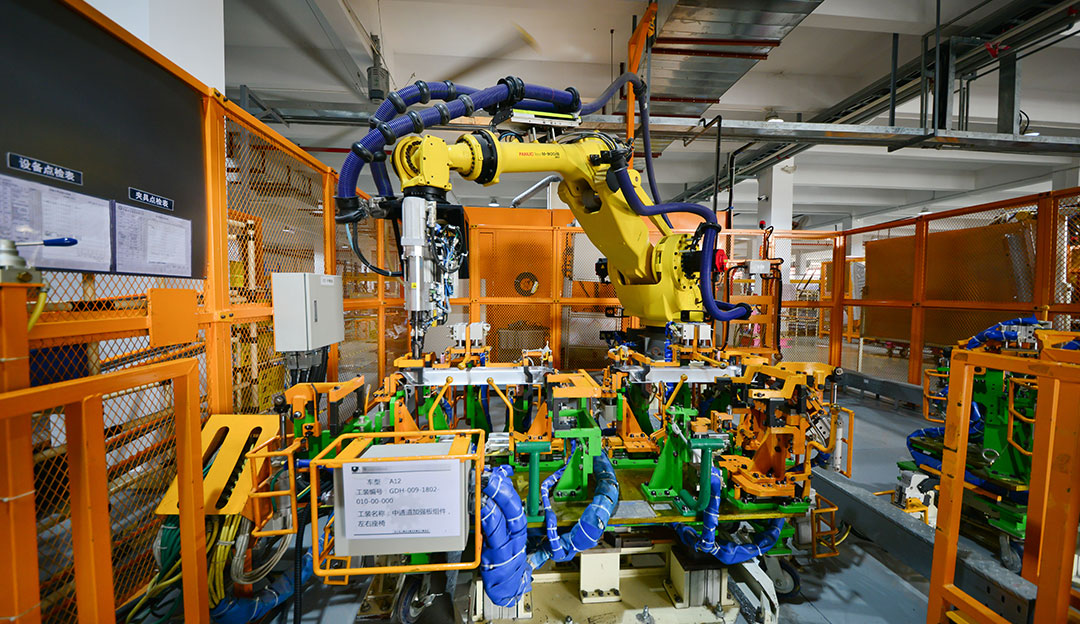 Automated manufacturing cell with robot and metal parts.