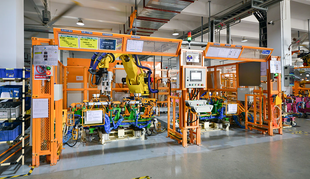Automated manufacturing cell with robots and safety guarding.