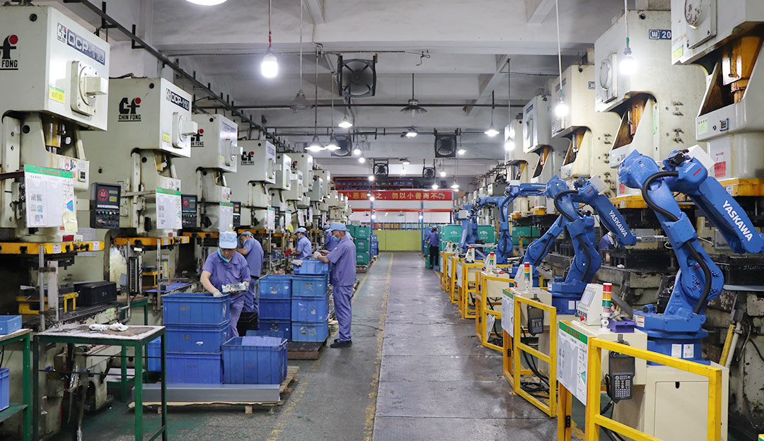 Production line with blue equipment and robotic workstations.