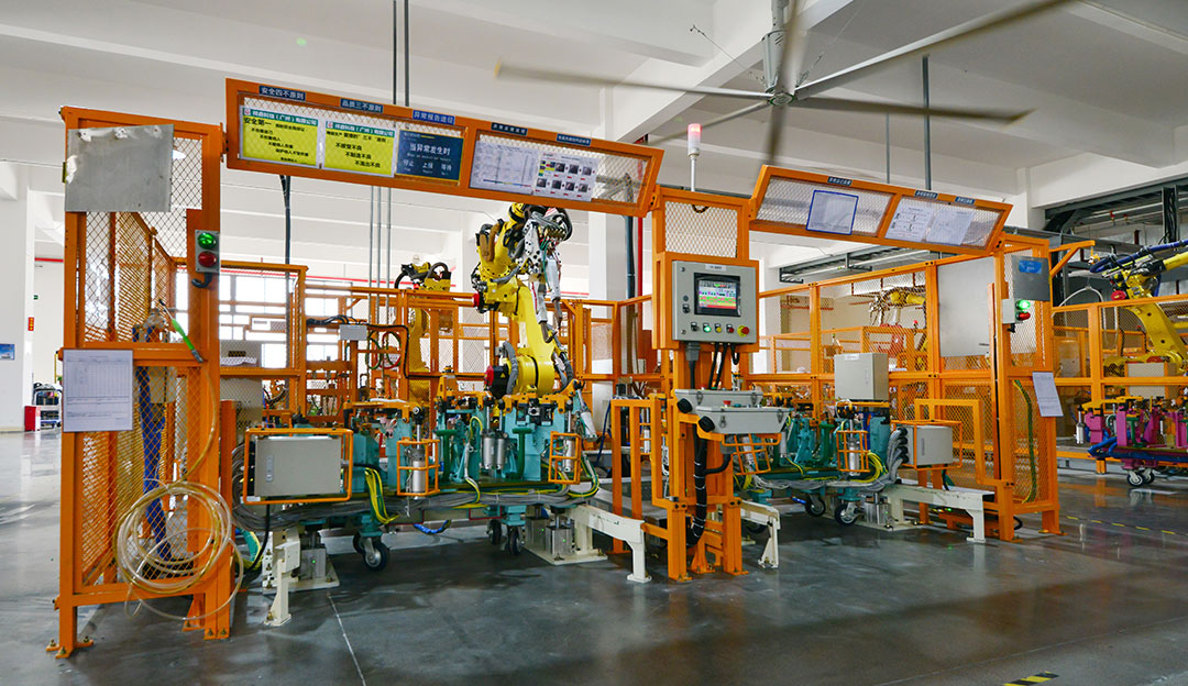 Robotic or automated production cell with orange guarding.