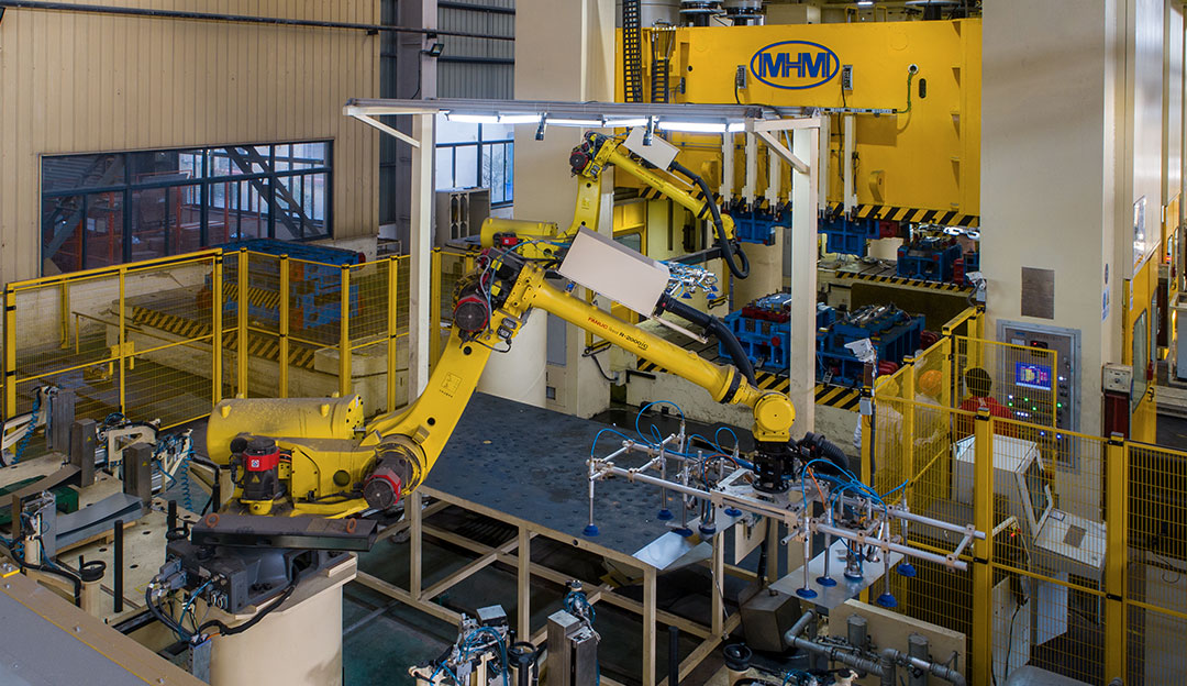 Yellow robot/automation cell in production area.