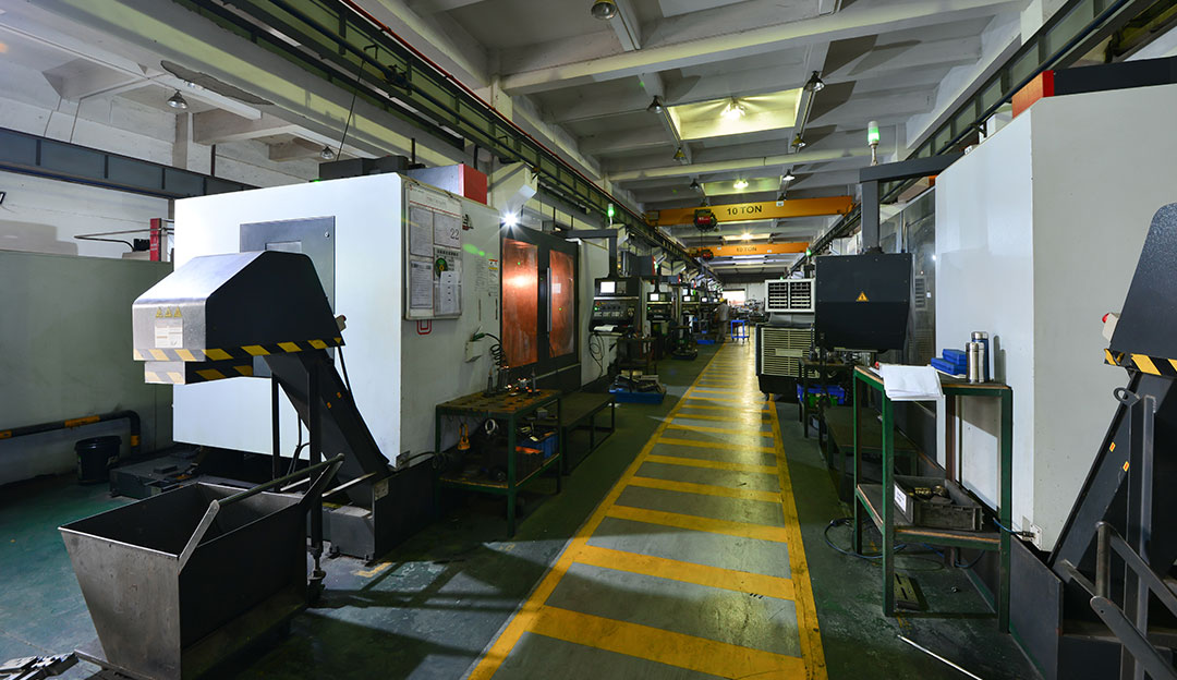 CNC machines and production equipment in a clean factory aisle.
