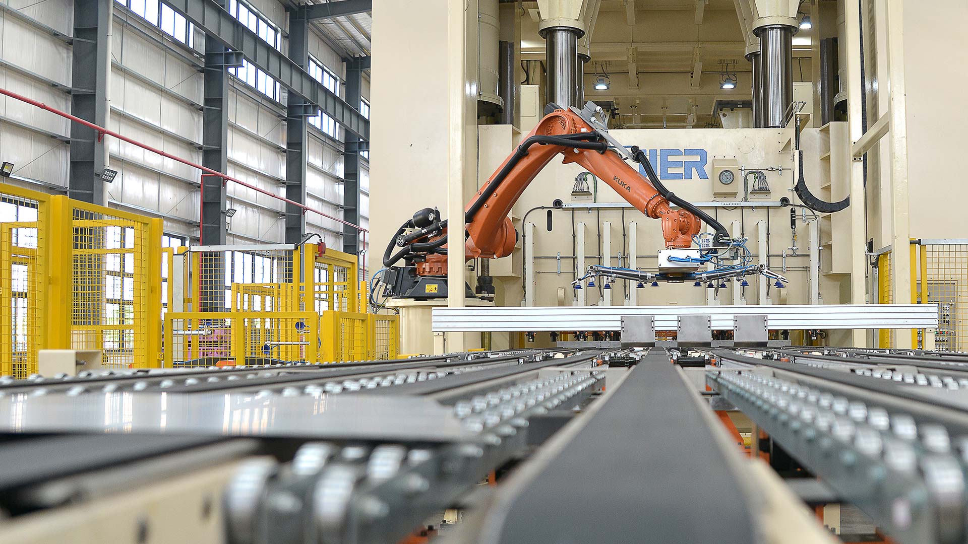 Close view of a robotic manufacturing line handling metal components.