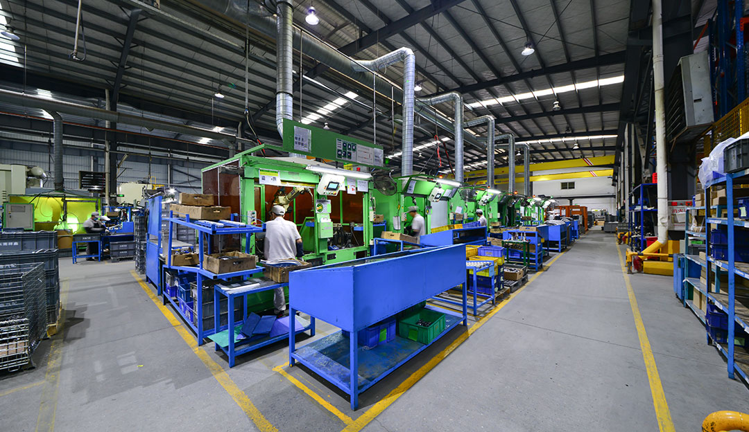 Wide production-floor view with workstations and metal structures.